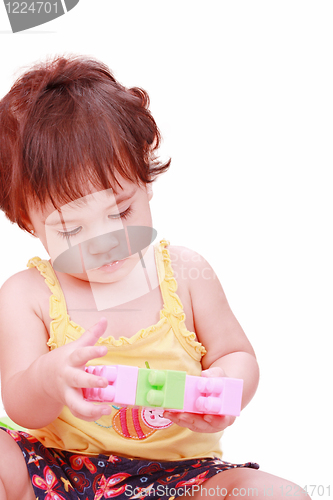 Image of Baby in yellow shirt playing with toys