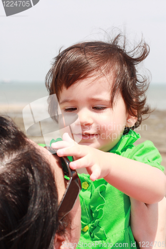 Image of Baby playing with mother taking her sunglasses