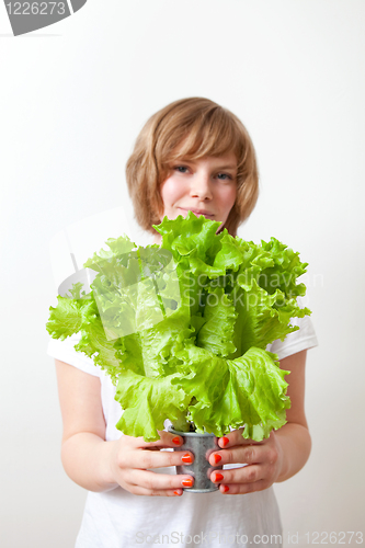 Image of Young woman holding lettuce