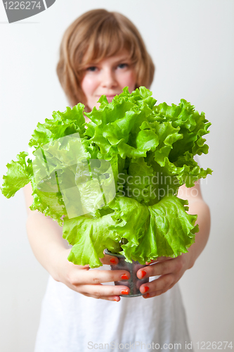 Image of Young woman holding lettuce