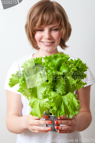 Image of Young woman holding lettuce