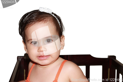 Image of Infant baby playing in her little baby bed at nursery.