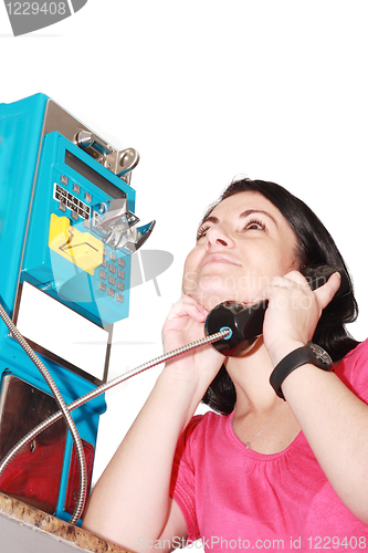 Image of Beautiful woman happy talking on the public phone