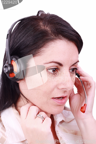 Image of A beautiful young telephonist speaking on a headset 