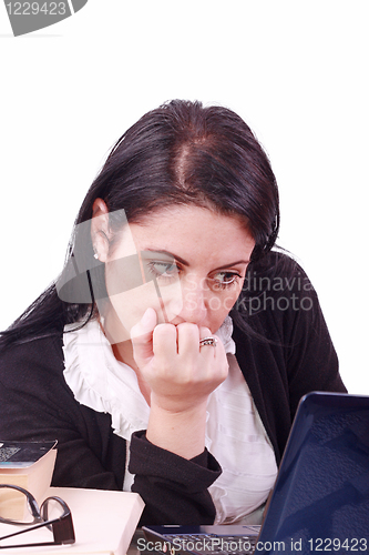 Image of Office worker with thoughtful look in front of laptop computer