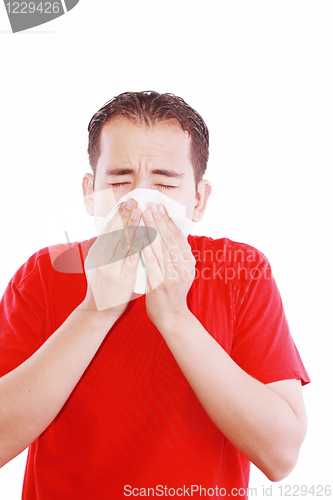 Image of Young man with a cold blowing nose on tissue 