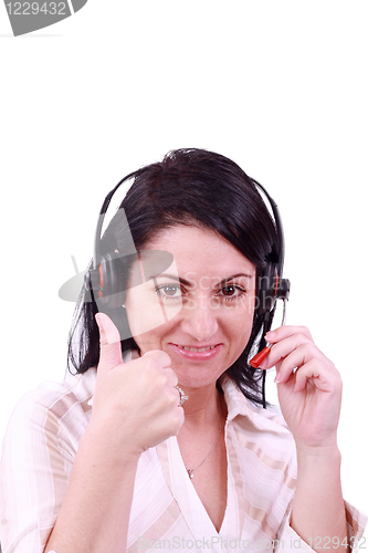 Image of smiling call center young woman with a headset thumb up 