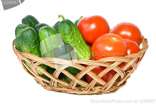 Image of Wicker basket with some tomatoes and cucumbers