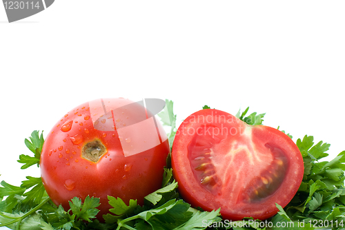 Image of Whole and half of tomato over some parsley