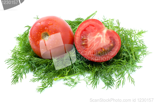 Image of Whole and half of tomato over some dill