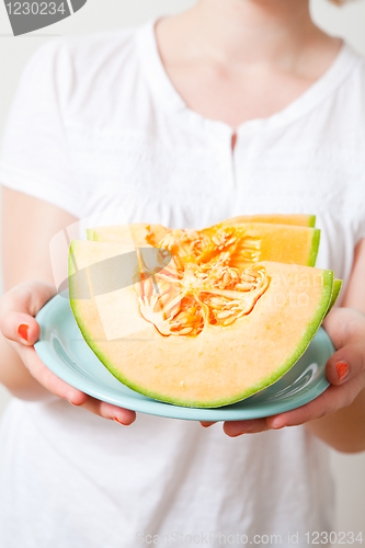Image of Woman with cantaloupe melon