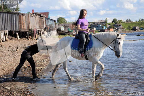 Image of Female lead a horse to swim