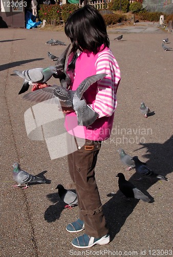 Image of Girl feeding pigeons