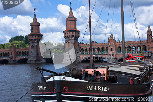 Image of old ship in front of a bridge