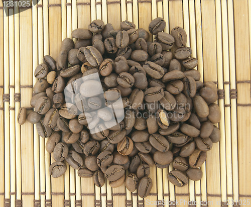 Image of A heap of coffee beans on wooden background