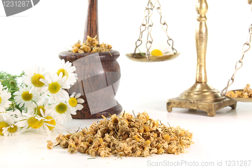 Image of chamomile flowers with mortar and scales