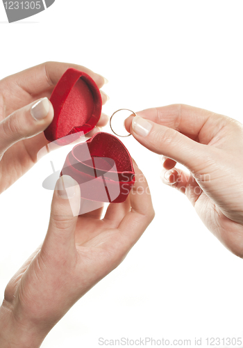 Image of Hands with a heart shaped box and a ring on white background