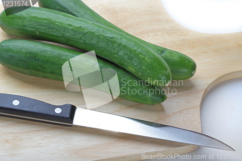 Image of Cutting cucumbers on the wooden board