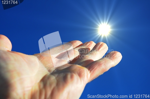 Image of hand sun and blue sky