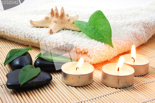 Image of foldet white bath towel and zen stones