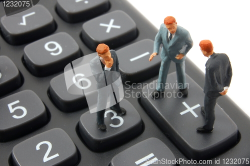 Image of toy business man on calculator isolated 