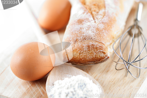 Image of bread, flour, eggs and kitchen utensil