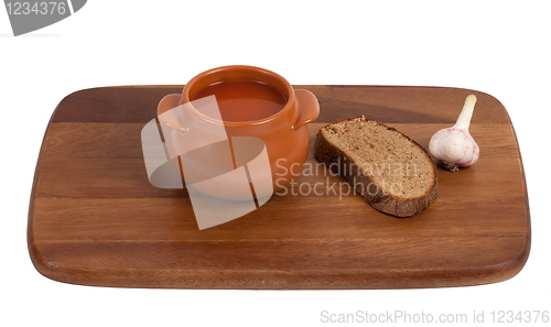 Image of Soup in clay pot on wooden kitchen board