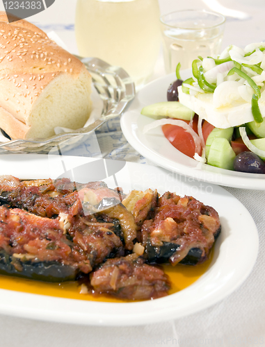 Image of Greek stuffed eggplant and Greek salad crusty bread wine