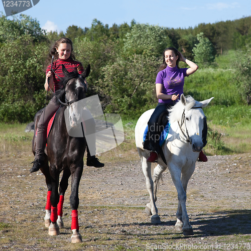 Image of Two girls riding horses