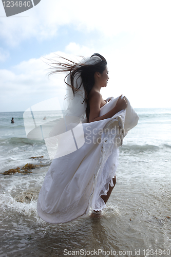 Image of Woman Running in the Ocean in her White Wedding Dress