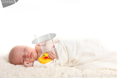 Image of Swaddled Infant Holding a Rubber Duckie