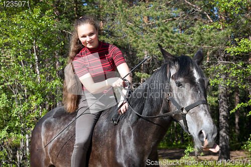 Image of Beautiful girl on black horse