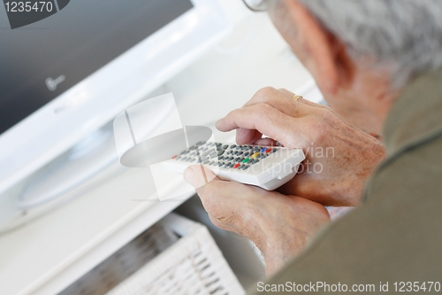 Image of Senior man watching tv