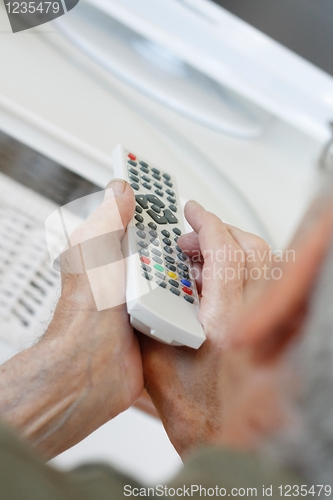 Image of Senior man watching tv