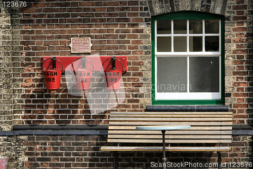 Image of fire buckets and seat in front of a window at a railway museum