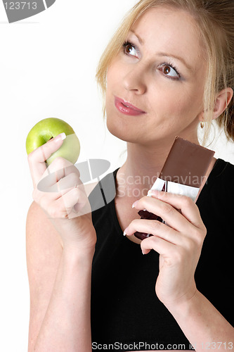 Image of woman deciding whether to eat apple or chocolate