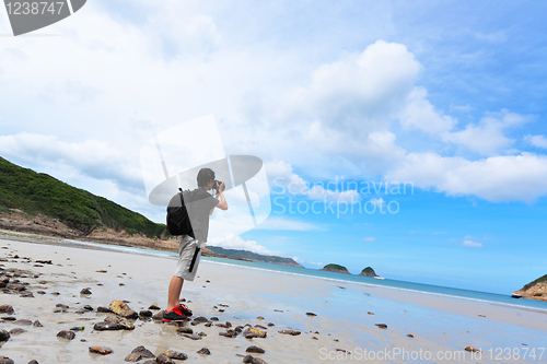 Image of Photographer taking photo on beach