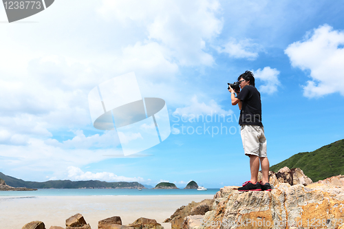 Image of Photographer taking photo on beach
