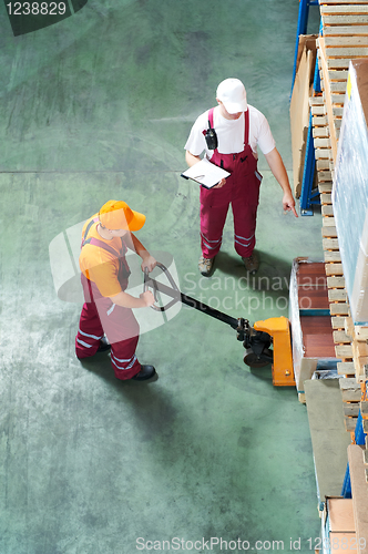 Image of Warehouse workers with fork pallet truck stacker