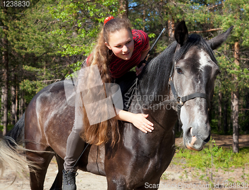 Image of A girl with her hair stroking horse