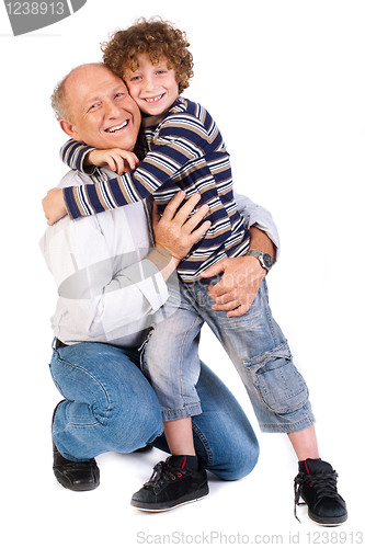 Image of Grandson hugging his grandpa, indoors