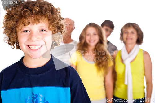 Image of Adorable young kid in focus with family in the background