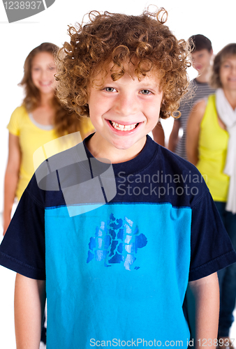 Image of Smiling kid in focus with family posing in the background