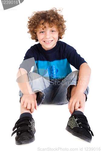 Image of Adorable young kid sitting on floor