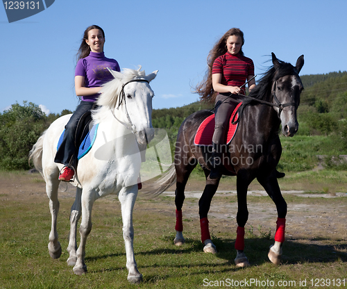 Image of Two girls walking on horseback