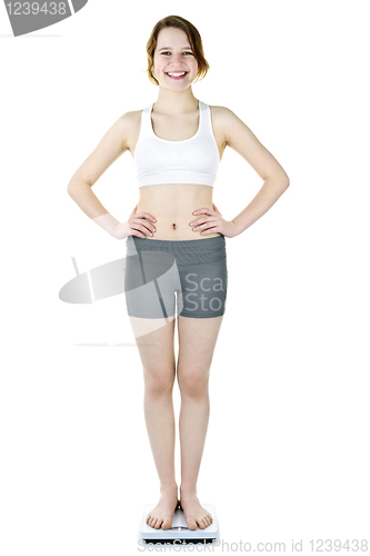 Image of Teenage girl standing on bathroom scale smiling