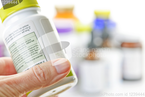 Image of Hand holding medicine bottle