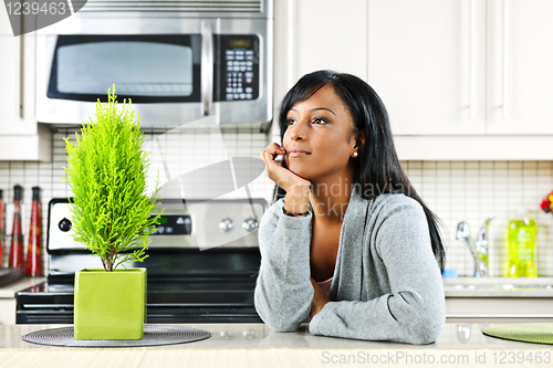 Image of Thoughtful woman in kitchen