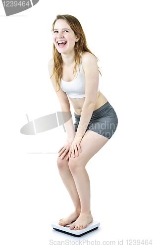 Image of Excited fit young girl on bathroom scale