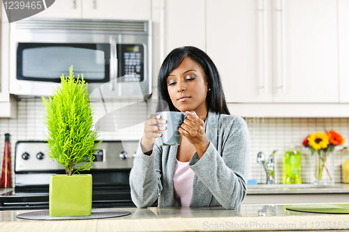 Image of Woman in kitchen with coffee cup